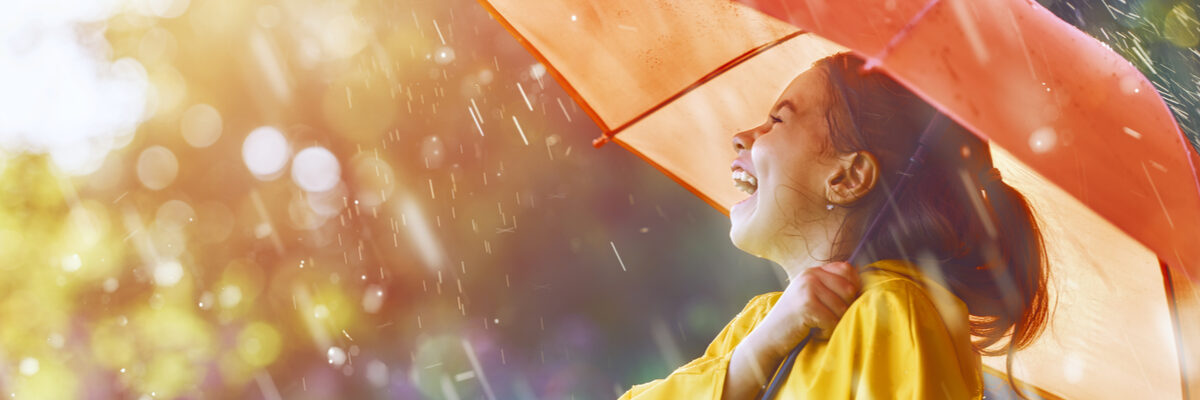Laughing girl holding an umbrella in the rain