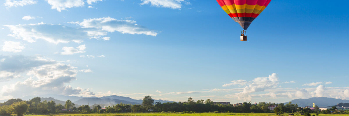 Colourful hot air balloon over a green field
